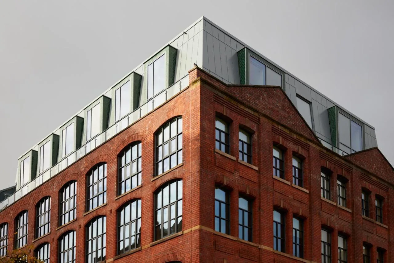 Red brick building with metal roof at Leven Manchester, Chorlton Street, Manchester city centre