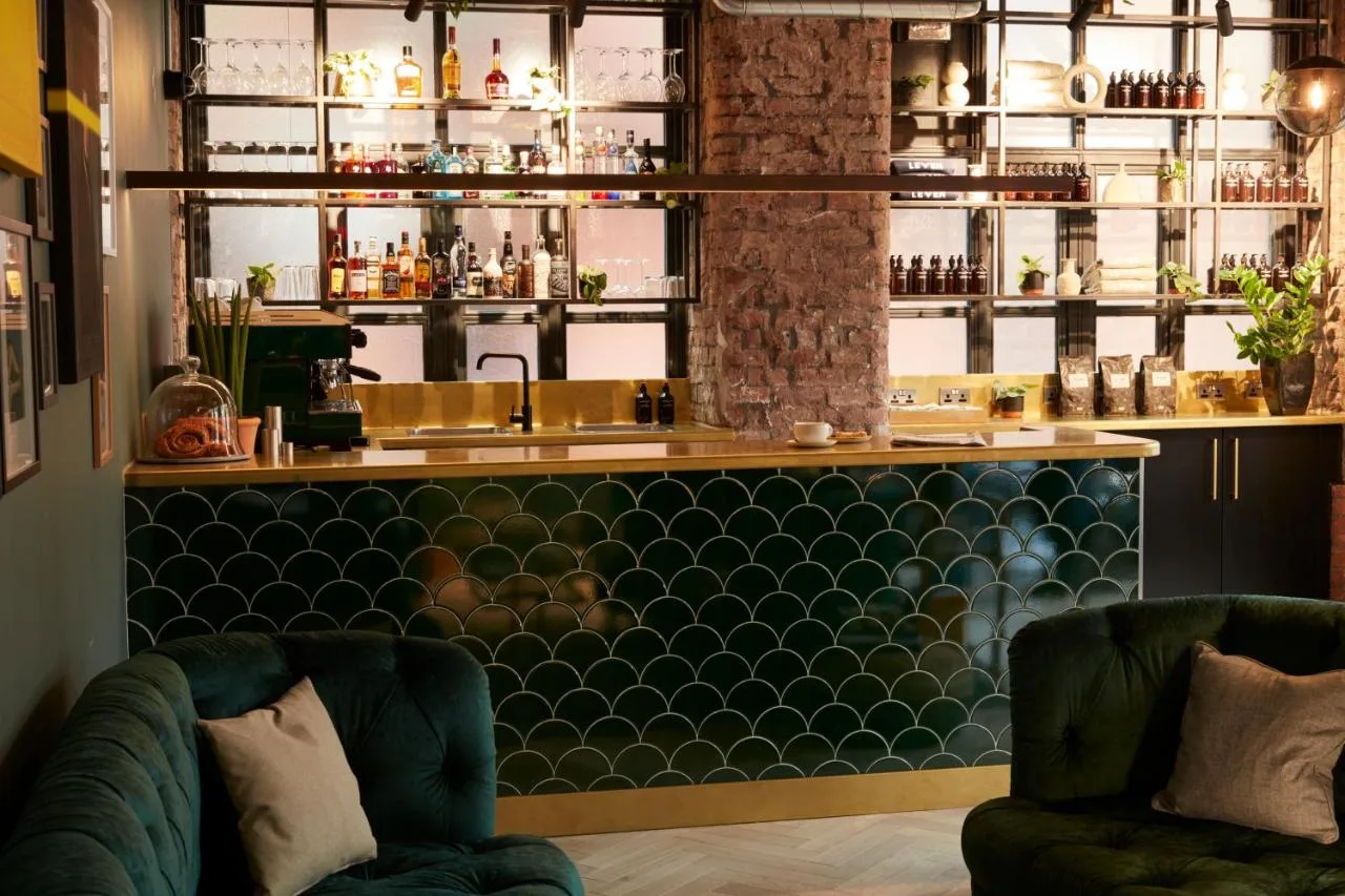 Hotel bar with green chairs at Leven Manchester in Manchester city centre